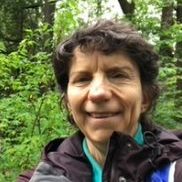 A professional headshot of Callie K LeVina, Founder of The Inner Architect Method, smiling warmly in a natural outdoor setting.